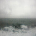 the seas through a ferry window covered in rain